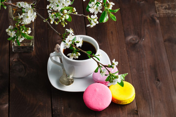 Cup of coffee with cookies macaroon branch of cherry