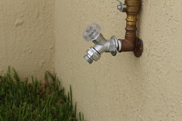 a water spigot on the side of a wall