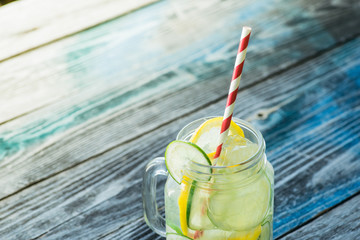 Jar with infused detox water on wooden table