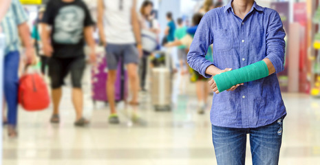 injured woman with green cast on hand and arm on traveler in mot