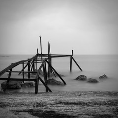 Black and white seascape with destroyed pier