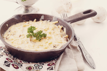 Casserole with chicken and mushrooms on the table.