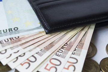 banknotes with coins and a purse on a white background
