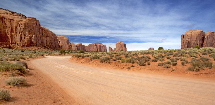 scenic and empty dirt road in monument valley