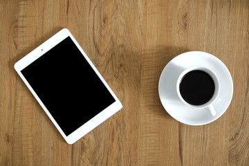 Digital tablet with coffee on wooden desk