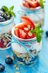 Strawberry blueberry yogurt parfait with addition of muesli, coconat flakes and fresh mint. Delicious dessert, perfect for a  breakfast