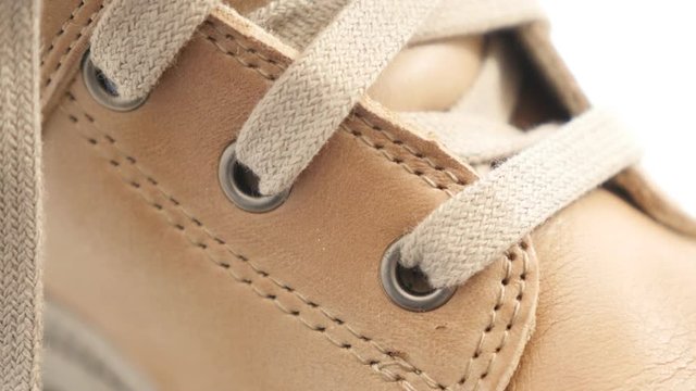 Female beige casual boots details of surface and style 4K 2160p 30fps UltraHD video - Close-up tilting on laces and stitches woman footwear 4K 3840X2160 YHD footage 