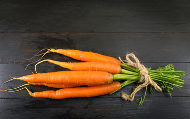 Fresh carrot bouquet on a wooden board