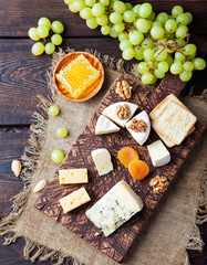 Assortment of cheese with honey, nuts and grape