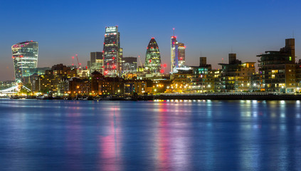 Cityscape of London with reflection in Thames river at night, UK