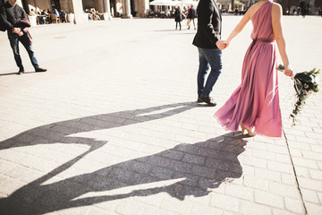 wedding. beautiful couple, bride with pink dress walking in the old city Krakow, their shadows