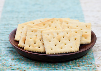 Square biscuit cracker in a wooden bowl