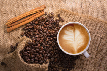 white coffee cup and roasted coffee beans around