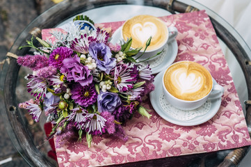 bridal bouquet and two cups of cappuccino. Heart of foam.