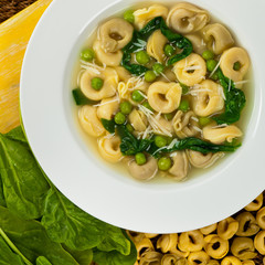 Tortellini Soup with Peas and Spinach. Selective focus.