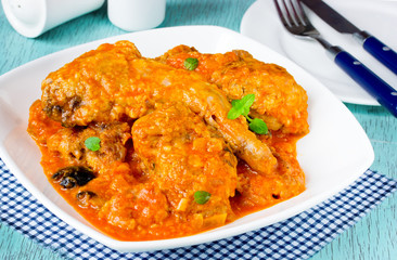 Rabbit meat in tomato sauce with black olives