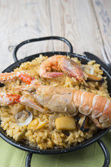 Vegetable paella with seafood on a wooden background