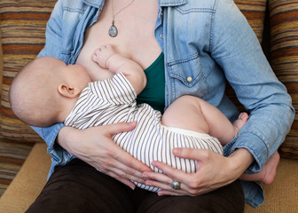 woman  holding and feeding a baby