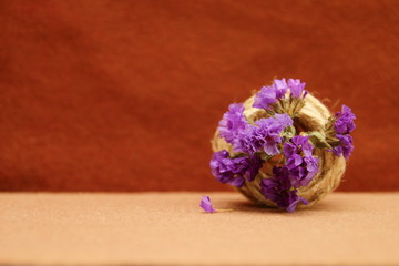 decorative composition of twine and flowers on a brown background