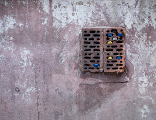 old wall with bottle caps in box