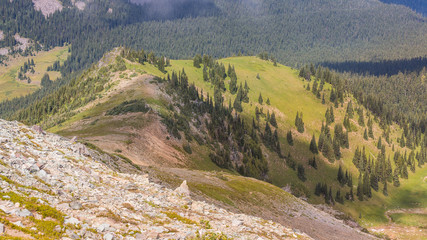 Fototapeta na wymiar Rocky slopes in the mountains. Amazing view at the peaks which rose against the cloud sky. Path on the tops of mountains. MOUNT FREMONT LOOKOUT TRAIL, Sunrise Area, Mount Rainier