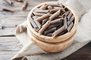 Uncooked italian buckwheat pasta on the wooden table