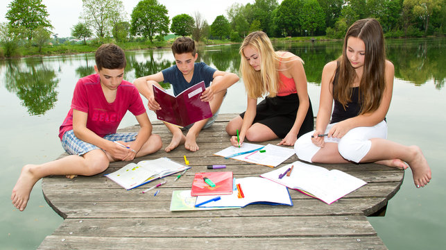 Jugendliche lernen gemeinsam draußen am See