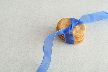 A stack of dog biscuits tied together with a blue ribbon