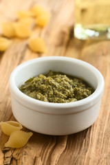 Pesto alla Genovese zubereitet aus Basilikum, Pinienkerne, Olivenöl und Knoblauch in kleiner Schüssel, fotografiert mit natürlichem Licht (Selektiver Fokus, Fokus ein Drittel in das Pesto)