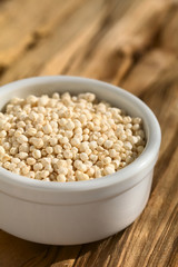 Gepuffte weisse Quinoa Samen (lat. Chenopodium quinoa) in kleiner Schüssel, fotografiert mit natürlichem Licht (Selektiver Fokus, Fokus ein Drittel in die Quinoa)