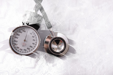 Blood pressure meter and stethoscope, on white background with snow effect