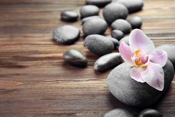 Naklejka na ściany i meble Spa stones and orchid flower on wooden background