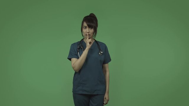 indian female doctor isolated on greenscreen with fingers on lips