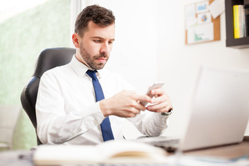 Obraz premium Businessman texting in an office