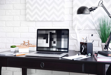 Workplace with laptop on table at home