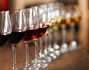 Many glasses of different wine in a row on bar counter