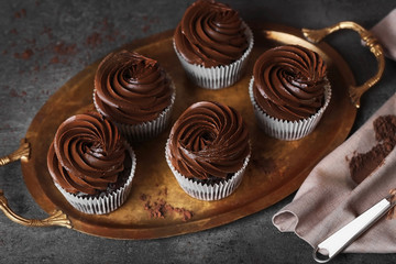 Chocolate cupcakes on a tray over grey background, close up