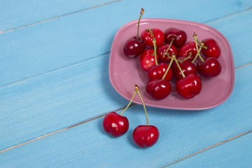 Obraz na płótnie Canvas cherry plate on blue table
