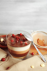 Delicious dessert with rowan in glass on table