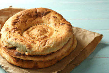 Flat bread on craft paper on wooden background