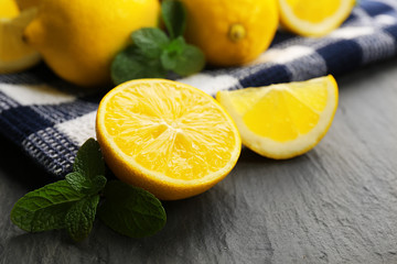 Slices of fresh lemon with green leaves on table closeup