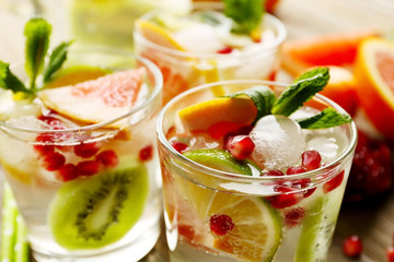 Refreshing cocktails with ice, mint, pomegranate seeds and slices of fruits