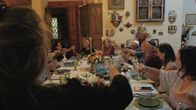 A large group of mixed generational people join in a toast