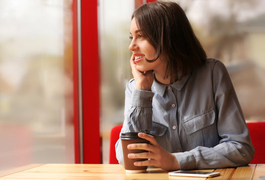 Young woman with coffee sitting in cafe