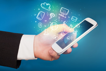 Hand holding smartphone with media icons