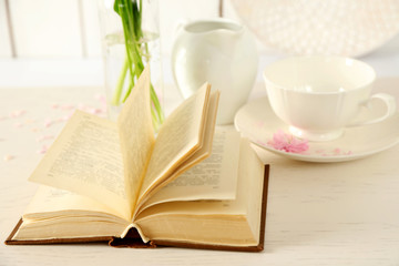 Open book with white tableware on table