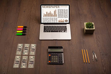 Business laptop with stock market report on wooden desk