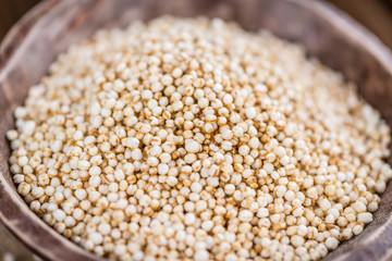 Puffed Quinoa (selective focus; close-up shot) on wooden backgro