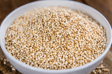 Puffed Quinoa (selective focus; close-up shot) on wooden backgro