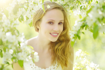 Fototapeta premium Young girl near the apple tree